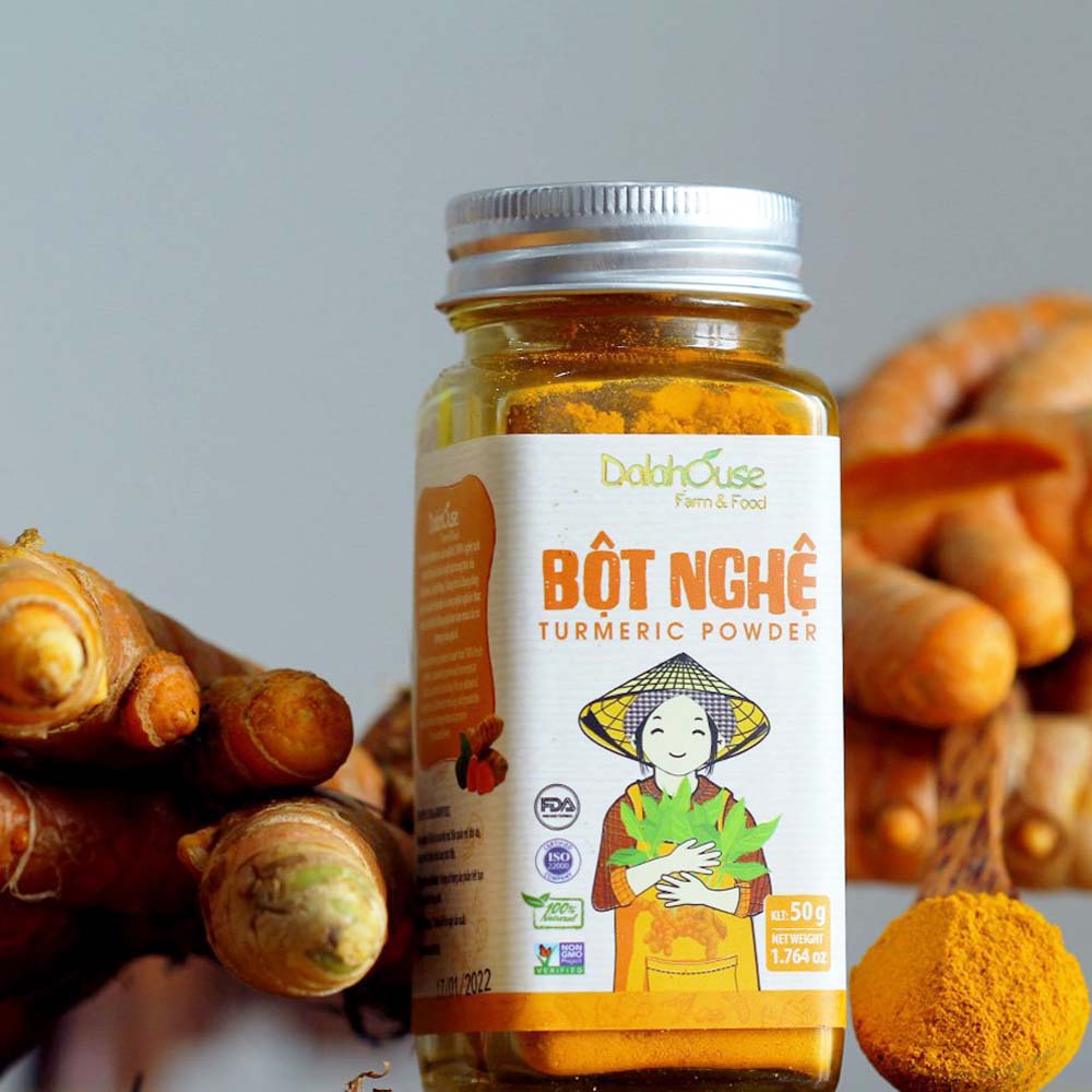 Hũ mật ong nghệ nguyên chất đặt cạnh củ nghệ tươi và thìa gỗ trên nền bàn gỗ, thể hiện công dụng làm đẹp và sức khỏe tự nhiên