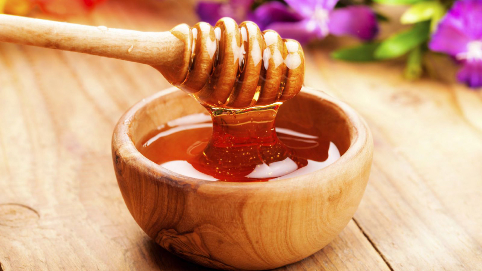 Bát mật ong nguyên chất đặt cạnh bã cà phê tươi dùng để tẩy tế bào chết tự nhiên cho da mặt