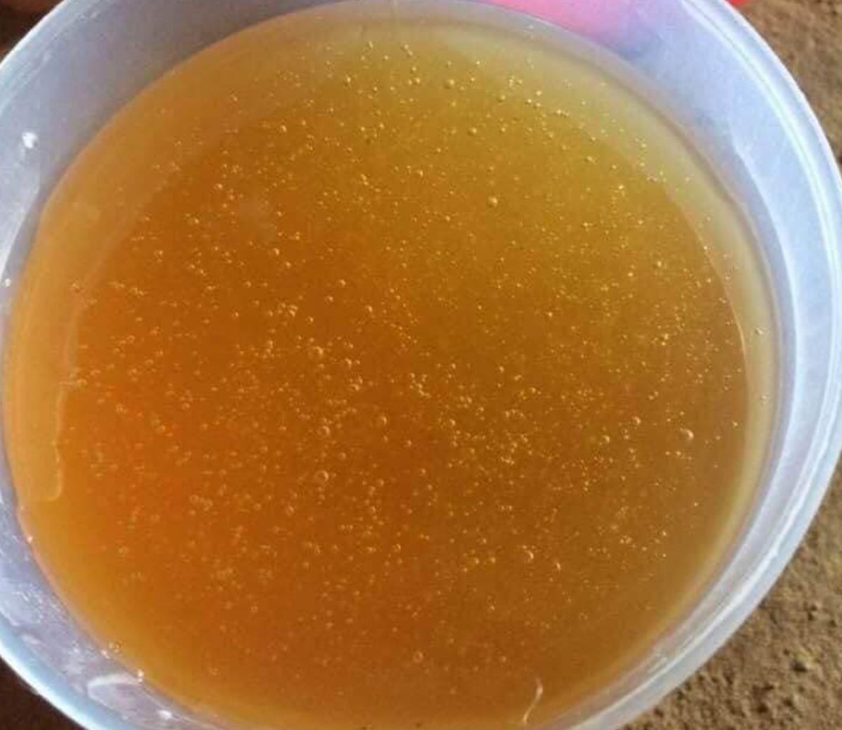 Cận cảnh bọt khí li ti và màu sắc vàng sẫm đặc trưng của mật ong rừng nguyên chất Việt Nam, nổi bật sự tự nhiên và giá trị dinh dưỡng cao.