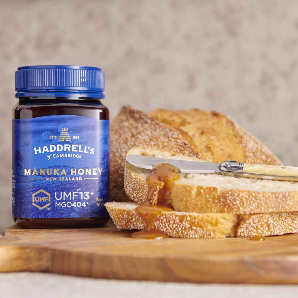 Cận cảnh hoa manuka trắng và lọ mật ong manuka nguyên chất nổi bật, minh họa sự khác biệt giữa mật ong Manuka và mật ong hoa Việt Nam