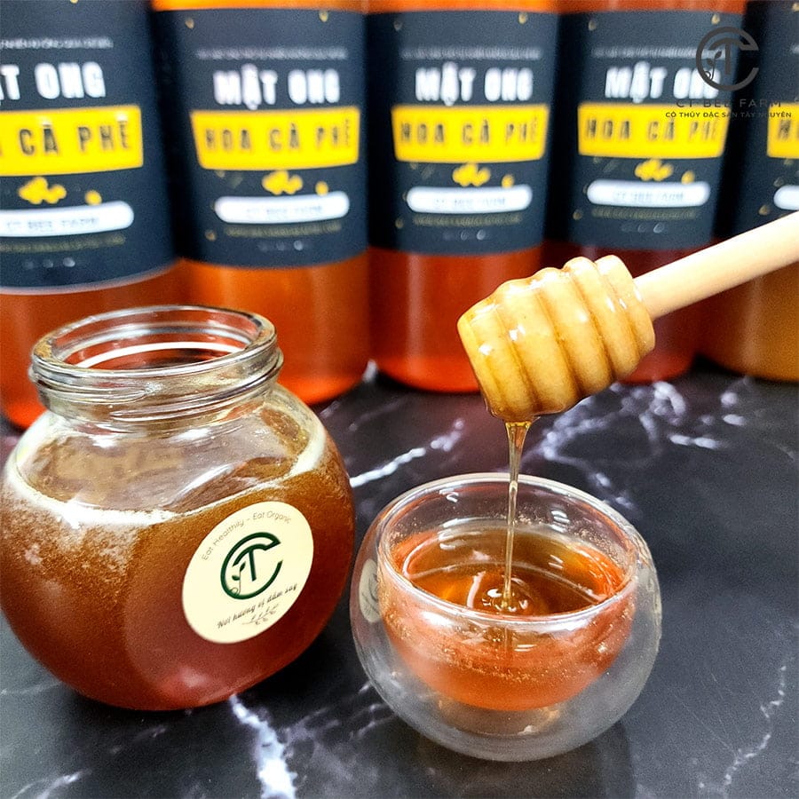 Khách hàng trải nghiệm thử nếm mật ong hoa nhãn và mật ong hoa cà phê tại cửa hàng, so sánh hương vị và màu sắc