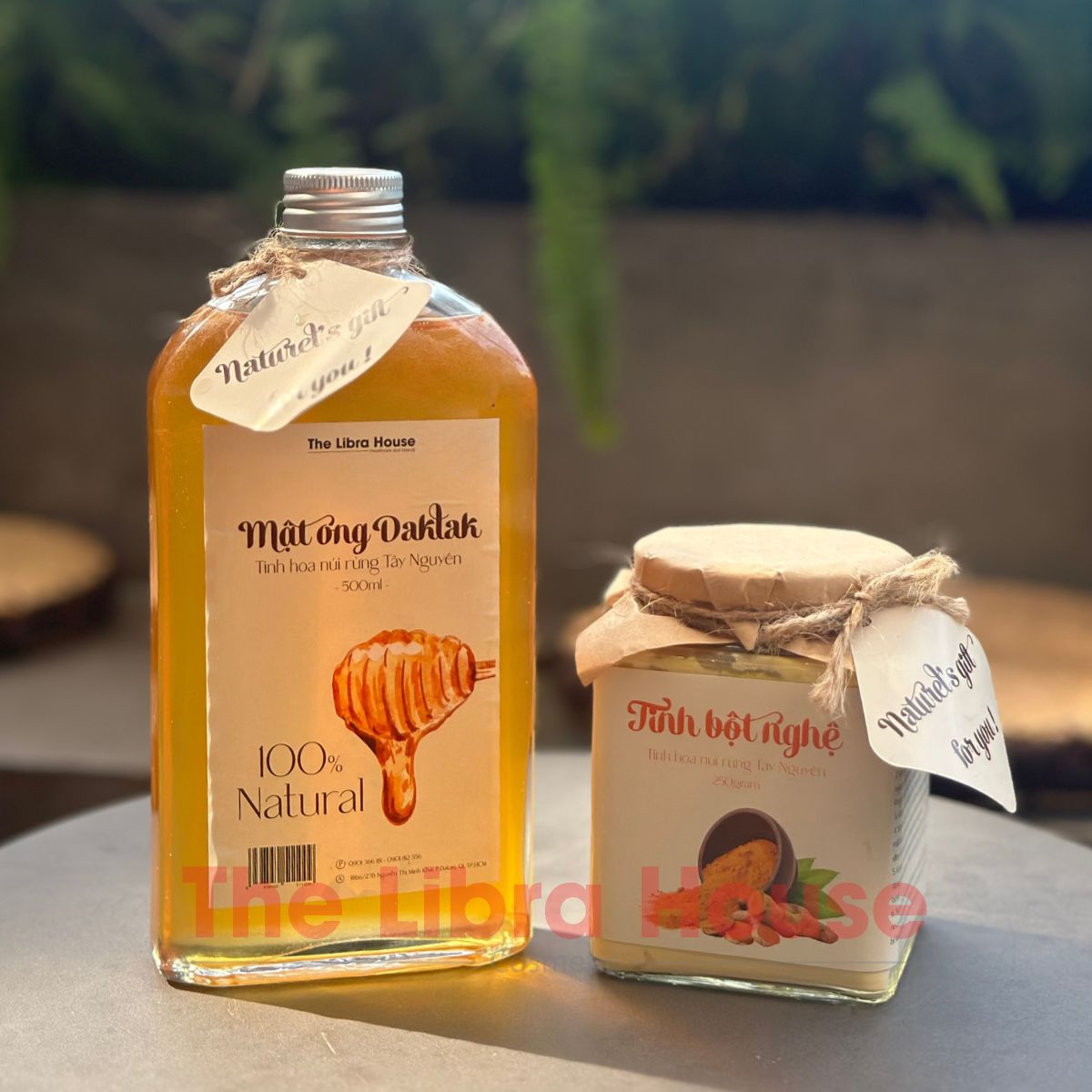 Lọ mật ong nguyên chất Việt Nam đặt cạnh hoa rừng đặc trưng, nổi bật màu vàng óng tự nhiên và hương sắc thiên nhiên Việt Nam