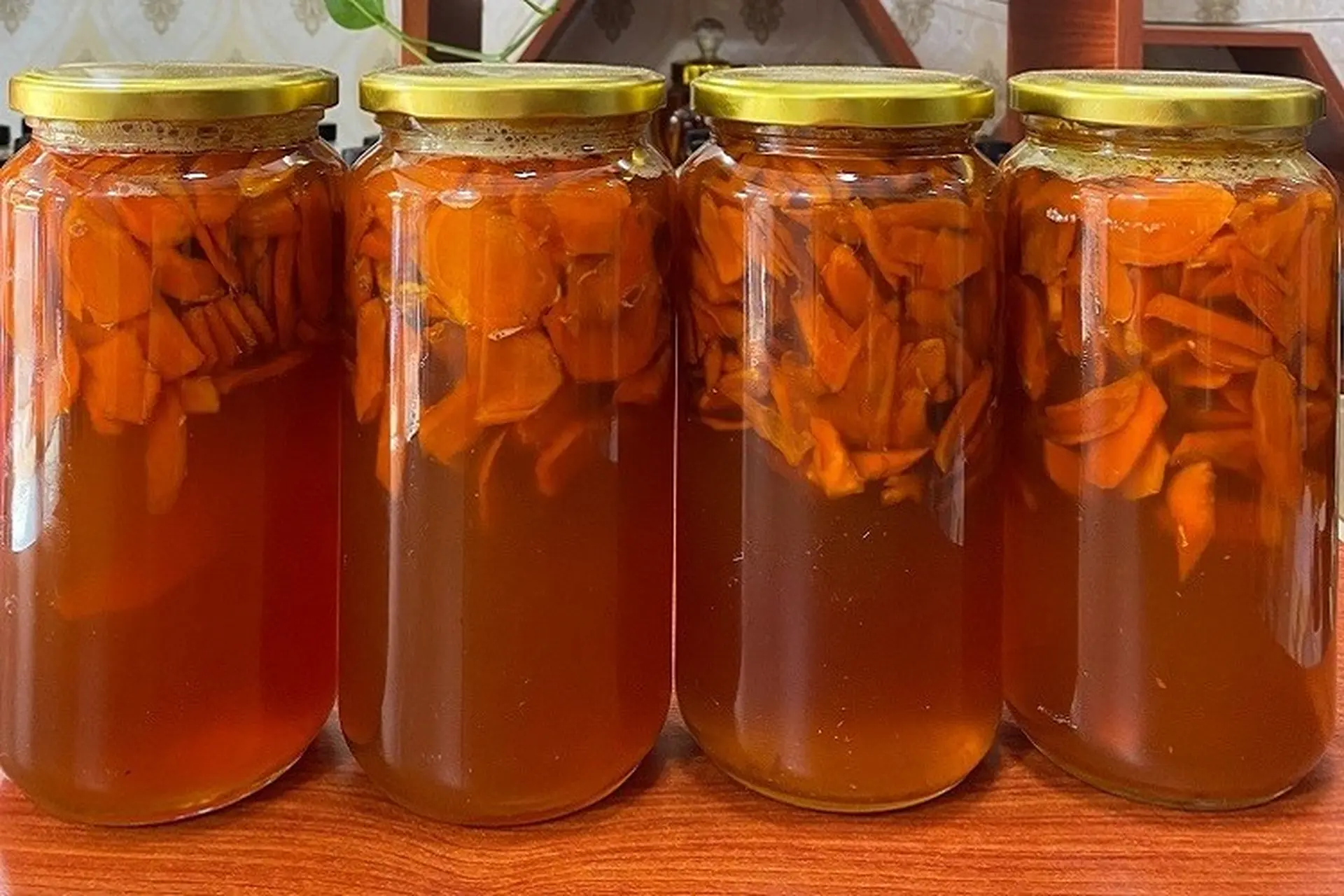 Mật ong nghệ vàng óng trong hũ thủy tinh đặt cạnh củ nghệ tươi thái lát, phù hợp cho bài viết về công dụng và cách làm mật ong nghệ tại nhà.